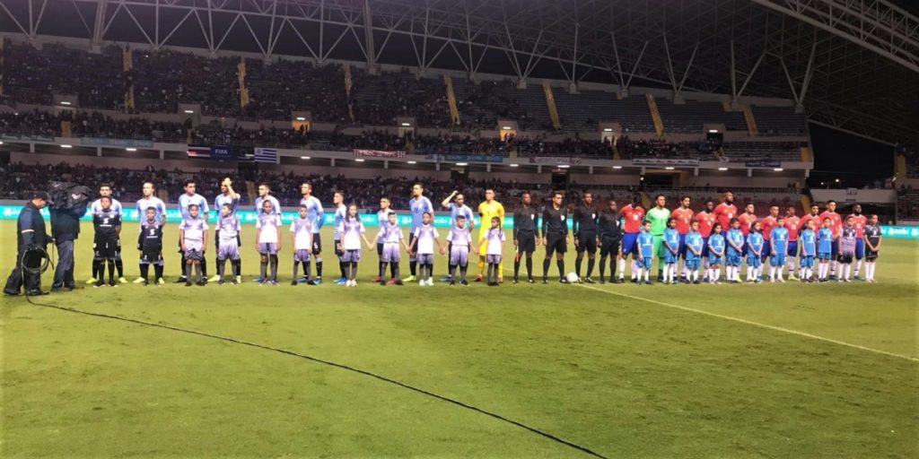 Los seleccionados de Costa Rica (derecha) y Uruguay durante la entonación de los Himnos Nacionales de ambos países, previo al amistoso del pasado 6 de setiembre en el Estadio Nacional de San José (foto de la Asociación Uruguaya de Fútbol).